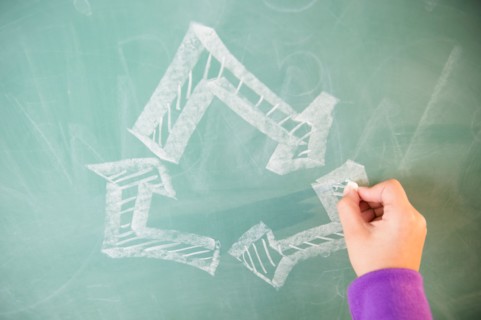 View of arrows on blackboard and girl's hand