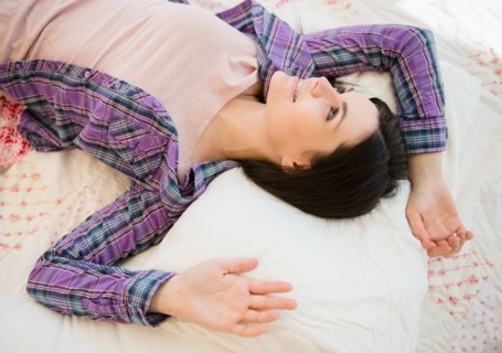 Portrait of relaxed young woman lying down on bed