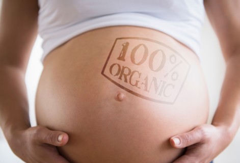 Mid section of pregnant woman with label on belly