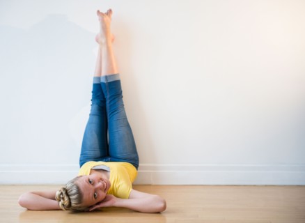 Portrait of teenage (16-17) ballerina lying down with feet up against wall