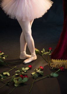 Teenage (16-17) ballerina on stage, roses by her feet