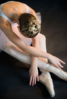 Teenage (16-17) ballerina bending over
