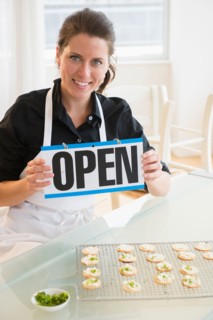 Portrait of woman holding open sign