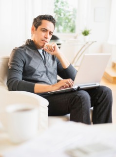Portrait of man working on laptop at home