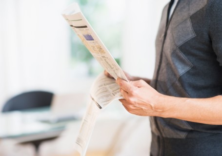 Mid section of man holding newspaper