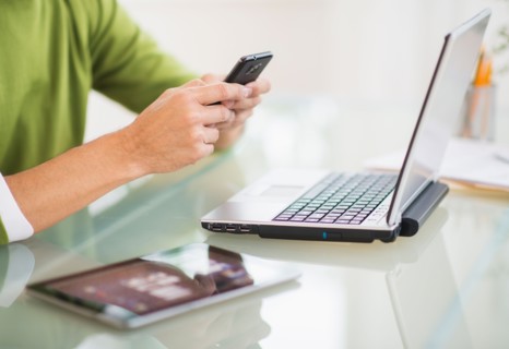 Mis section of man using mobile phone at desk