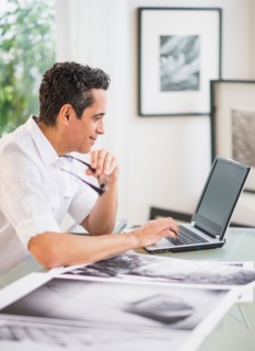 Portrait of man in his photography studio using laptop