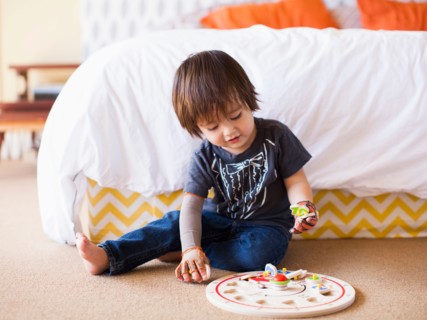 Baby boy (2-3) playing in bedroom