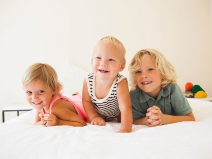 Portrait of boy (6-7), girl (2-3) and their baby brother (6-11 months)