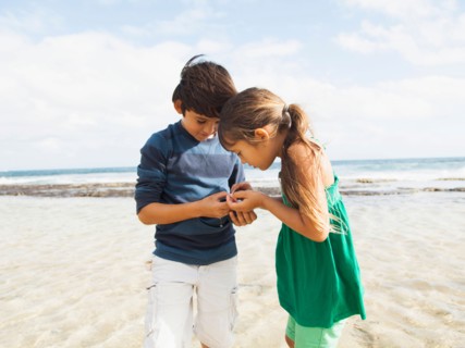 Portrait of girl (6-7) and boy (10-11) on beach