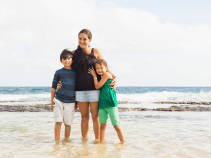 Portrait of girl (6-7) and boy (10-11) standing on beach with mother