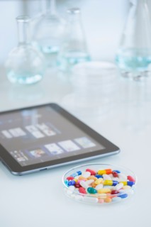 Studio shot of tablet pc and colorful pills.