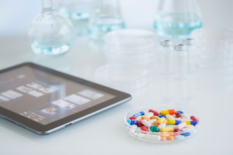Studio shot of tablet pc and colorful pills.