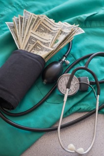 Studio shot of blood pressure monitor with money.