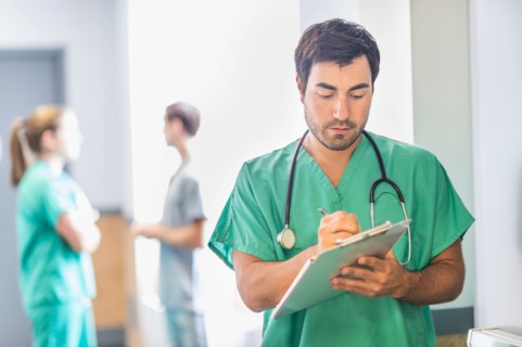 Male doctor in hospital hallway.