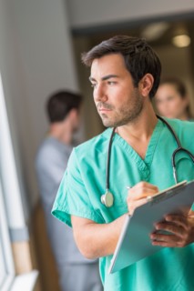 Male doctor in hospital hallway.