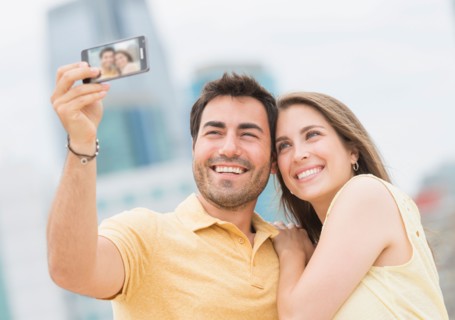 Couple taking self portrait photo with smartphone.
