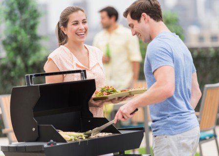 Friends enjoying barbecue in garden.