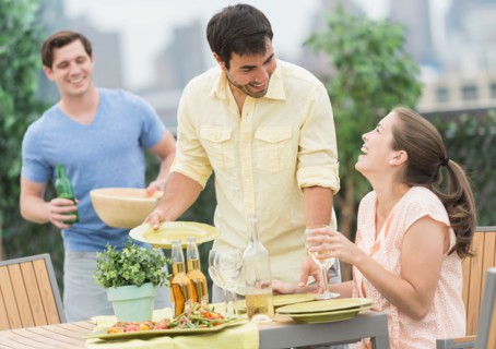 Friends enjoying barbecue in garden.