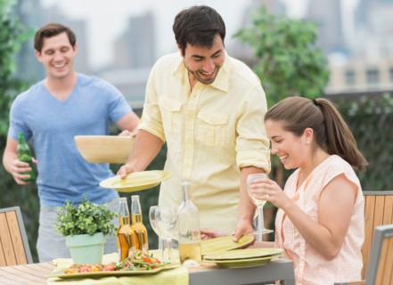 Friends enjoying barbecue in garden.
