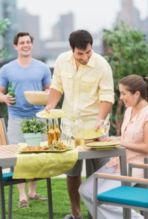 Friends enjoying barbecue in garden.