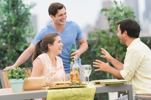 Friends enjoying barbecue in garden.