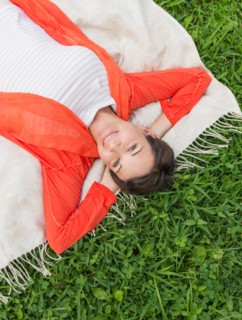 Mature woman lying on grass.