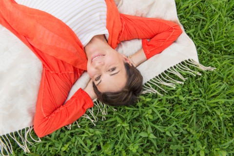 Mature woman lying on grass.