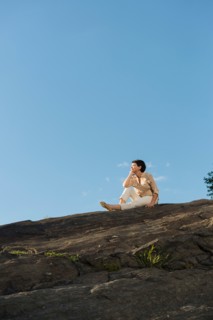 Mature woman sitting on rock.