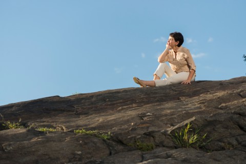 Mature woman sitting on rock.
