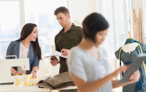 Three fashion designers working in studio.