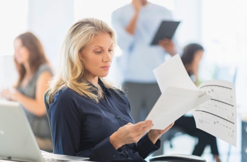 Woman reading at desk in office.