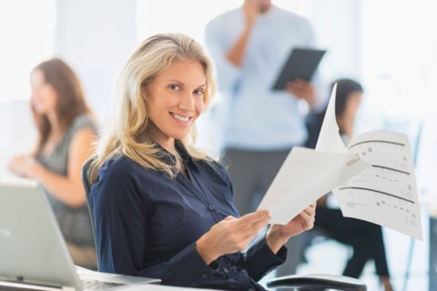 Woman smiling at desk in office.