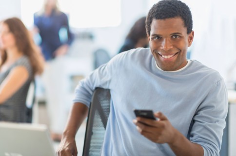 Man smiling at desk in office.