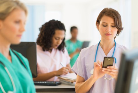 Doctors and nurses working at desks in hospital.