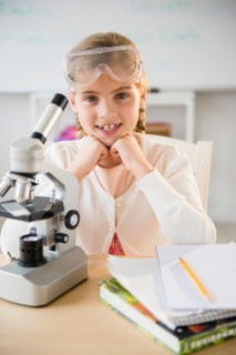 Portrait of girl (8-9) with microscope