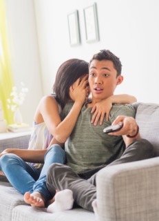 Young woman and young man sitting on sofa