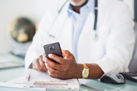 Close up of doctor's hand holding mobile phone