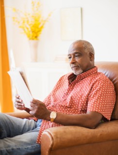 Portrait of men reading newspaper in armchair