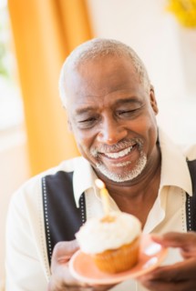 Portrait of man holding cupcake with candle