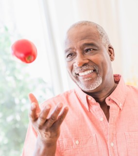 Portrait of man throwing red apple