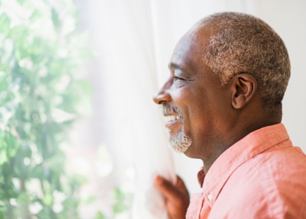 Portrait of smiling man looking through window