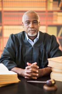 Portrait of judge in courtroom, gavel in front