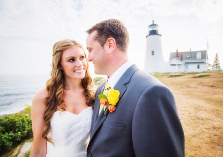 Portrait of married couple, lighthouse in background