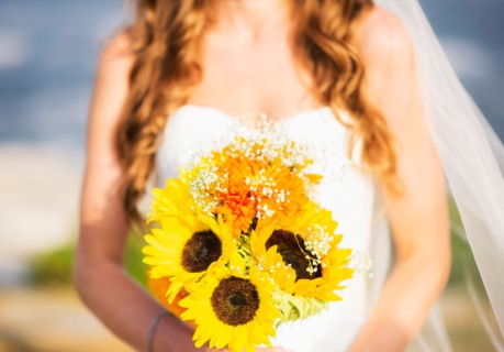Mid section of bride holding sunflower bouquet