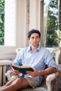 Portrait of young man relaxing with book