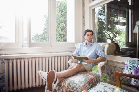 Portrait of young man relaxing with book