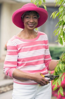 Portrait of senior woman pruning branch