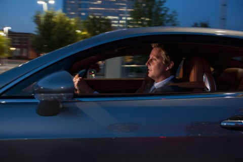 Profile of businessman driving car