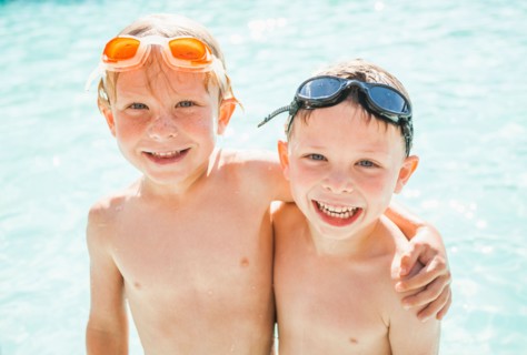 Two boys (4-5) playing in swimming pool